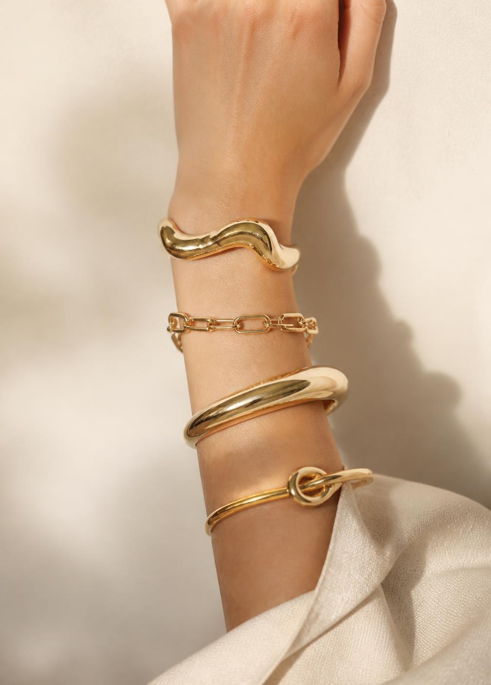 Sculptural LUEL gold bracelets worn on the wrist